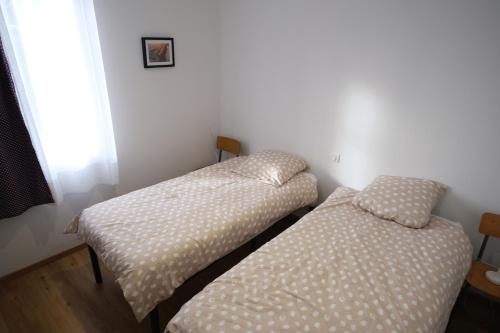 two twin beds in a room with a window at Gîte et Chambres d'hôtes du Musée Ecole in Le Monastier sur Gazeille