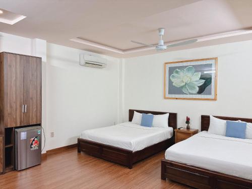 a hotel room with two beds and a tv at Luna Rossa Villa in Hoi An