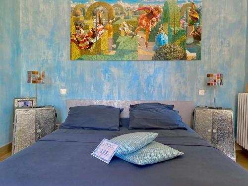 un lit avec deux oreillers et un tableau au mur dans l'établissement Domaine De Sainte Annette, à Callian