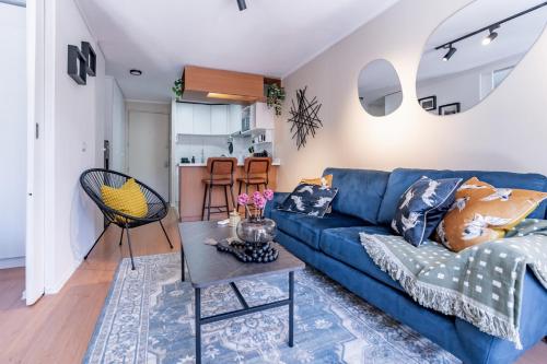 a living room with a blue couch and a table at San Carlos rentals - Lastarria in Santiago