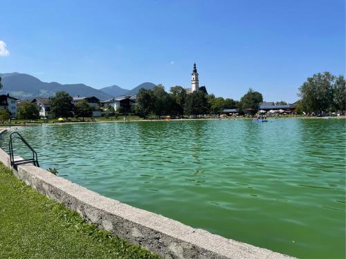a large body of water with a clock tower in the background at Haus KaiserInn - komfortable Wohnung 82 qm TOP ausgestattet, 2 Schlafzimmer mit Balkon und Bergblick in Flintsbach