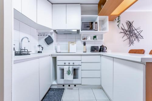 a white kitchen with white cabinets and appliances at San Carlos rentals - Lastarria in Santiago