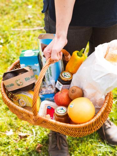 a person holding a basket of food and groceries at SCHILCHERLANDLEBEN - Kellerstöckl in Sankt Stefan ob Stainz