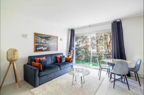 un salon avec un canapé bleu et une table dans l'établissement Appartement disign CLUB B, à Cannes
