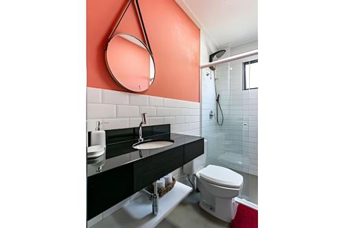 a bathroom with a sink and a mirror and a toilet at Loft moderno e espaçoso no centro de Floripa -UN30 in Florianópolis