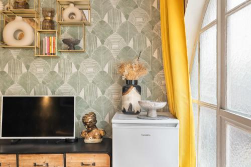 - un salon avec une télévision et un mur dans l'établissement Superb Historical Studio next to Louvre and Opera, à Paris