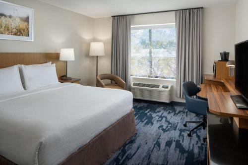 a hotel room with a bed and a desk and a window at Fairfield Inn & Suites by Marriott Fort Myers Cape Coral in Fort Myers