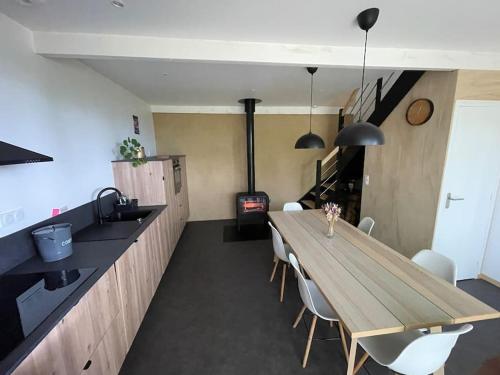 a kitchen with a wooden table and chairs and a stove at Grange Plouer centre entre St Malo et Dinan in Plouër-sur-Rance