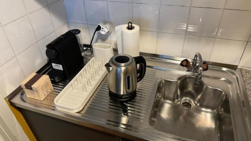 un comptoir de cuisine avec une bouilloire et un évier dans l'établissement Ferdinands Gateaway inkl Breakfast, à Berne