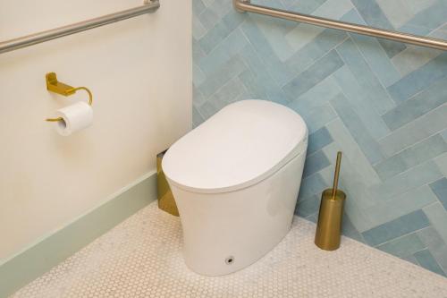 a white toilet in a bathroom with a toilet paper roll at The Boardwalk Hotel in San Diego
