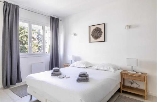 une chambre blanche avec un lit blanc et une fenêtre dans l'établissement Appartement disign CLUB B, à Cannes