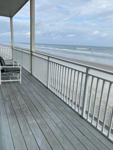 a balcony with a bench on the beach at Coastal Waters in New Smyrna Beach