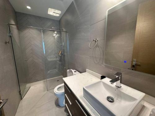 a bathroom with a sink and a shower and a toilet at Elegant 5-Bedroom Apartment in Exclusive Playa Escondida Pet Friendly in María Chiquita