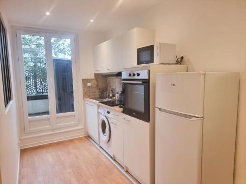 a kitchen with a refrigerator and a washer and dryer at ExigeHome - Appartement en plein centre-ville in Montigny-le-Bretonneux