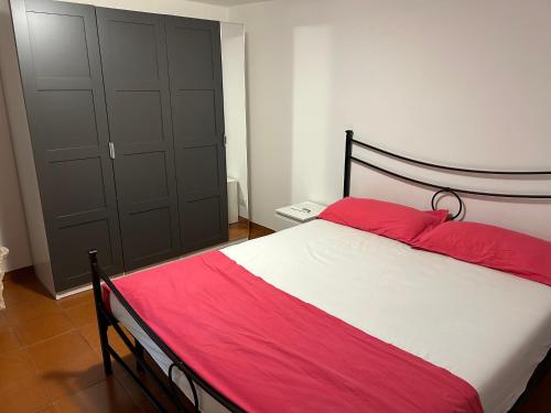 a bedroom with a bed with red and white sheets at Aba Gianola in Formia