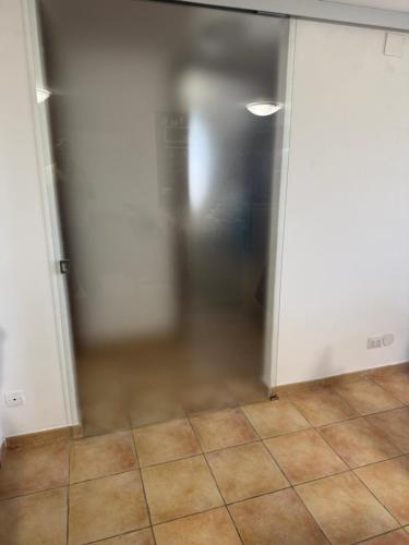 a glass door in a room with a tile floor at Aba Gianola in Formia