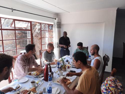 a group of men sitting around a table eating food at Matopo Ingwe Lodge in Matopos