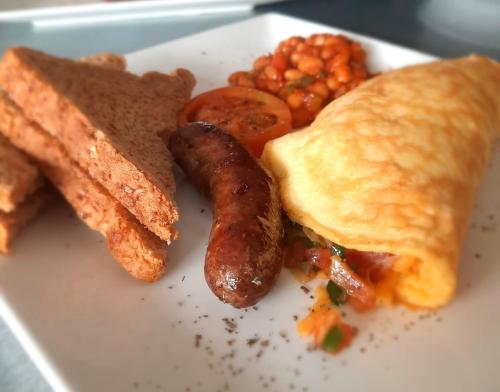 a plate of breakfast food with a sausage and toast at Matopo Ingwe Lodge in Matopos