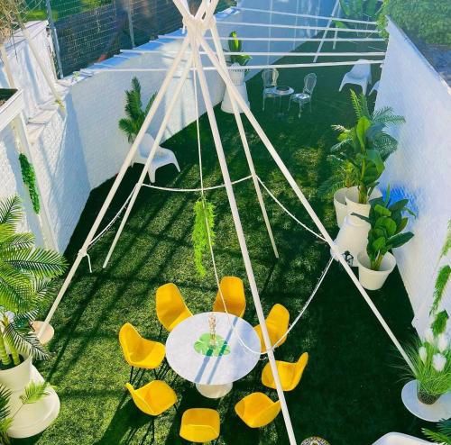 an overhead view of a patio with a table and yellow chairs at 05 -BALI Style Room - Tourcoing in Tourcoing