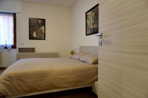 a bedroom with a bed and two pictures on the wall at Rustic Apartment -100mt from BerninaExpress in Tirano