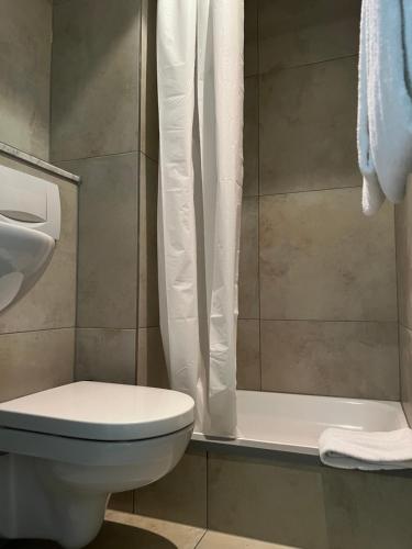 a bathroom with a toilet and a shower at Hotel Monopol City Centre in Düsseldorf