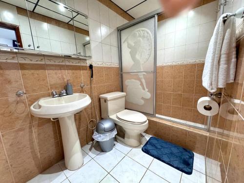 Un baño con inodoro, lavabo y ducha. en SC Central Suite, en Manta
