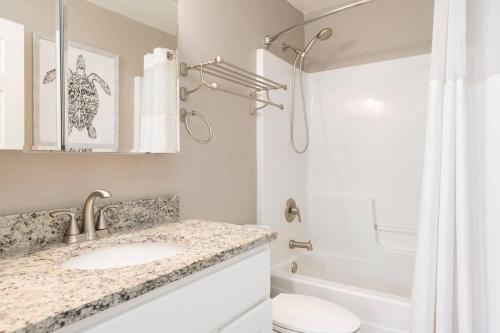 un bagno bianco con lavandino e doccia di The Little Haven - Charming Coastal Cottage a South Haven