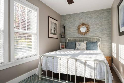 una camera con un letto bianco e due finestre di The Little Haven - Charming Coastal Cottage a South Haven