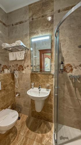 a bathroom with a sink and a toilet and a shower at Hotel Viliam Frano in Nitra