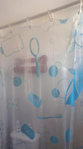 a shower curtain with a tennis racket on it at Eco Pousada Tigipió in São Mamede