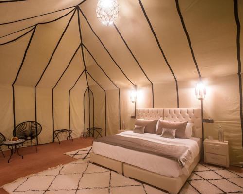 A bed or beds in a room at Luxury Merzouga Desert Camp