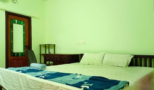 a bedroom with a bed with a blue blanket on it at Angels' homestay Marari in Mararikulam