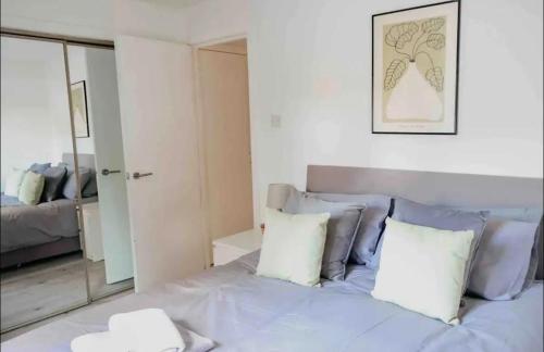 a bedroom with a bed with pillows and a mirror at Glasgow City - 1 Bedroom Apartment in Glasgow