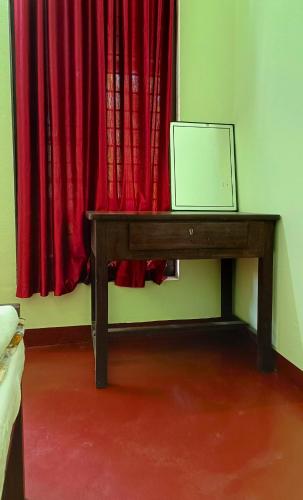 a wooden table with a laptop on it in front of a window at Angels' homestay Marari in Mararikulam