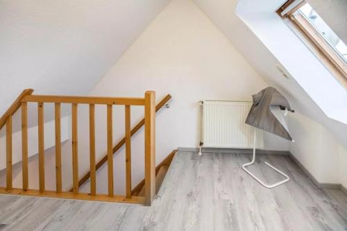 a attic room with a staircase and a fan at Haus Konstantin in Neßmersiel