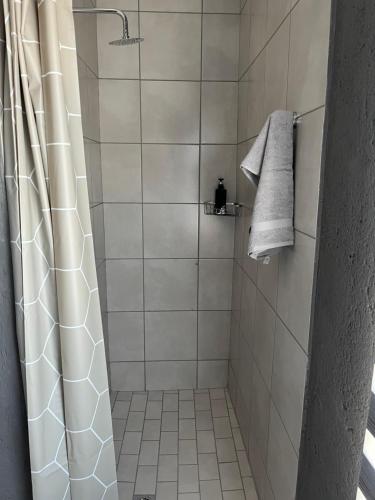 a bathroom with a shower with a shower curtain at Família BnB in Tekwane