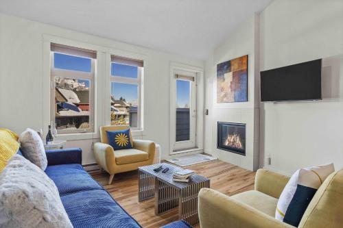 a living room with a blue couch and a fireplace at Freshly Remodeled - 2 King Beds- Breathtaking Views in Canmore
