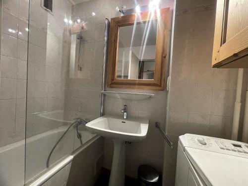 une salle de bain avec un lavabo, une baignoire et un miroir dans l'établissement OURS BLANC 20 Appartement 4 pers avec belle vue, à La Clusaz