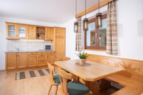 a kitchen with a wooden table and some chairs at Alpenrelax Krepperhütte in Volders