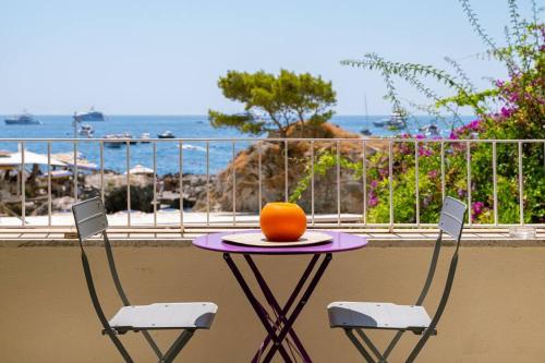 a table and two chairs with an orange on it at Dolce Vita Beach House stunning views by the sea in Capri