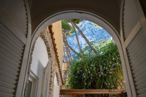 an arched window with a view of a mountain at Dolce Vita Beach House stunning views by the sea in Capri