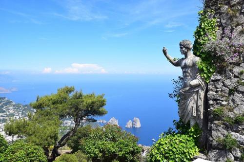 a statue of a woman standing on a mountain at Dolce Vita Beach House stunning views by the sea in Capri