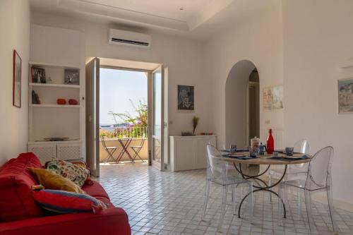 a living room with a red couch and a table at Dolce Vita Beach House stunning views by the sea in Capri