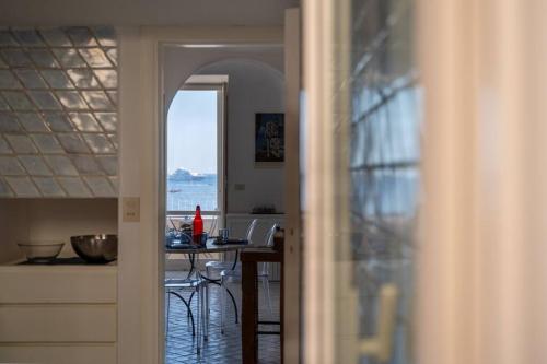 a kitchen and dining room with a view of the ocean at Dolce Vita Beach House stunning views by the sea in Capri