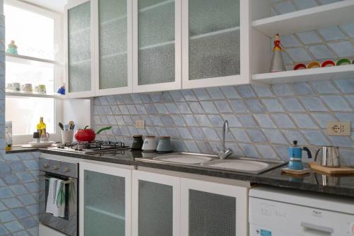 a kitchen with white cabinets and a counter top at Dolce Vita Beach House stunning views by the sea in Capri