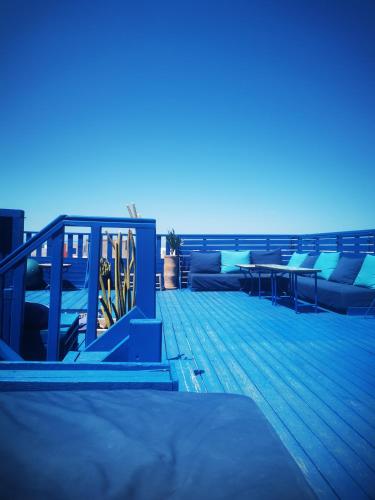 a deck with couches and tables on the beach at Tigmi Blue - Imsouane Surf et Océan in Imsouane