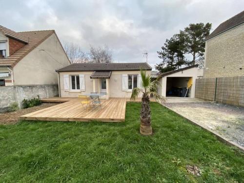 une maison avec une terrasse en bois dans la cour dans l'établissement Sweat little home close to Sword beach, à Ouistreham