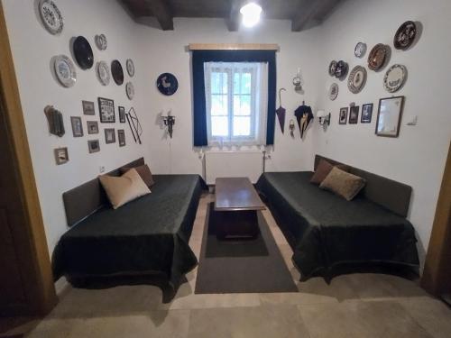 a living room with two beds and plates on the wall at Bike Stop Duna in Dunaszentmiklós