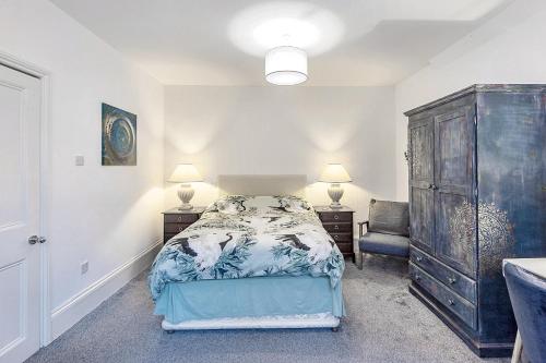 a bedroom with a bed and a dresser and a chair at 1 Bed flat in East Dulwich in London