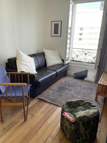 un salon avec un canapé en cuir noir et une table dans l'établissement Sunny, quiet 2-room apartment, 15th - Montparnasse, à Paris